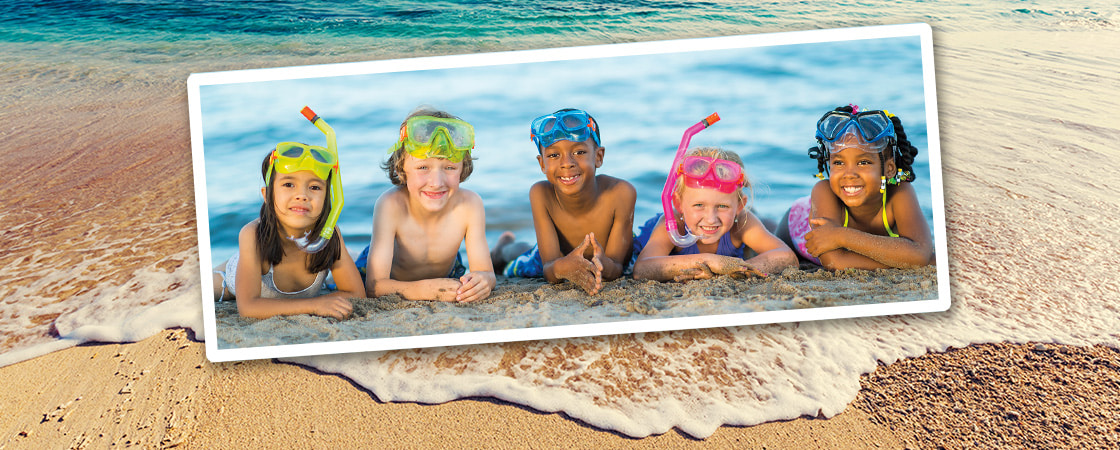 Image of five kids wearing scuba gear while laying on beach